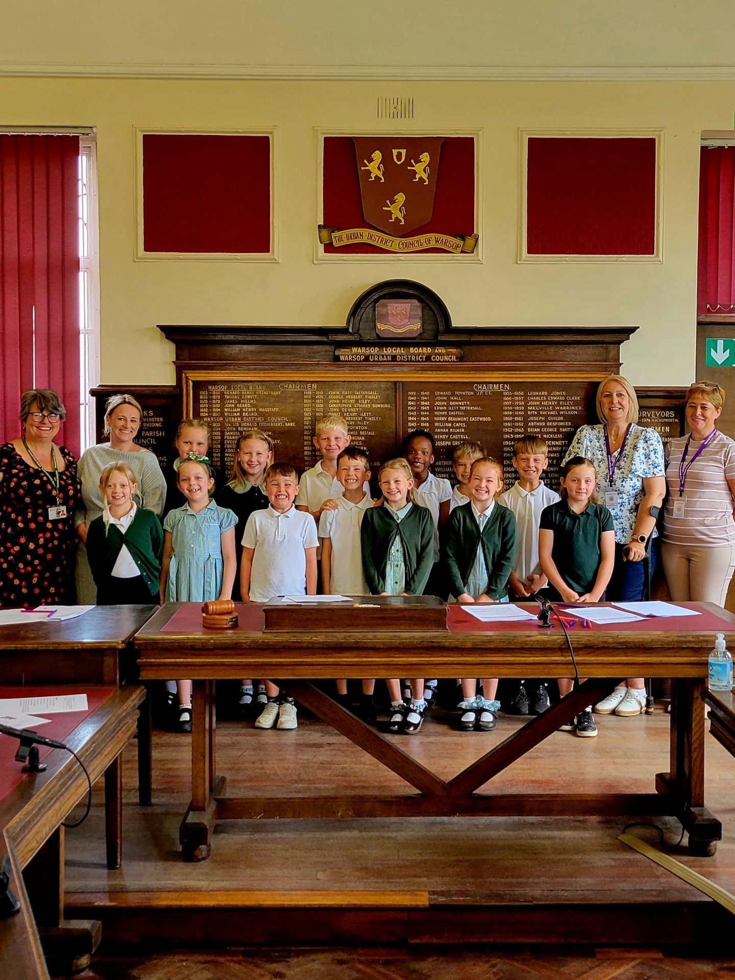 Local pupils pose for a group photo in the Council Chambers, with the Council Roll of Honour in the background.